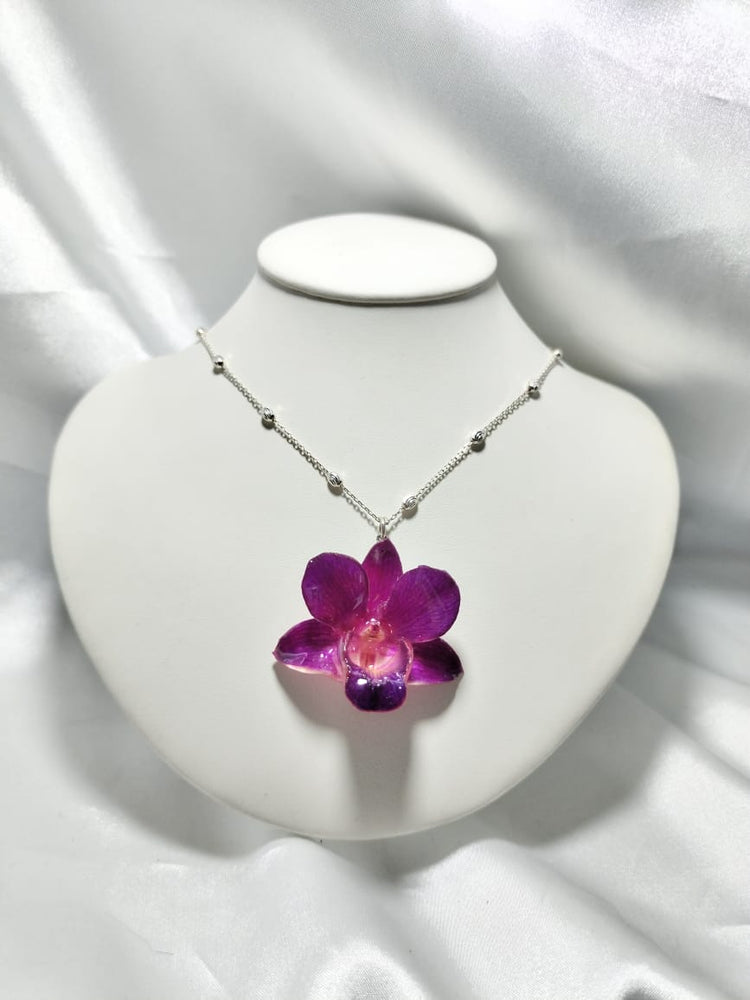 Dije de orquídea morada con cadena de bolitas de plata