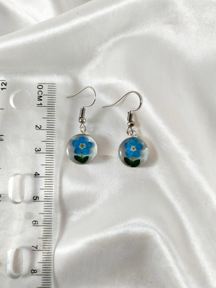 Aretes de mini flor de no me olvides con base de baño de plata